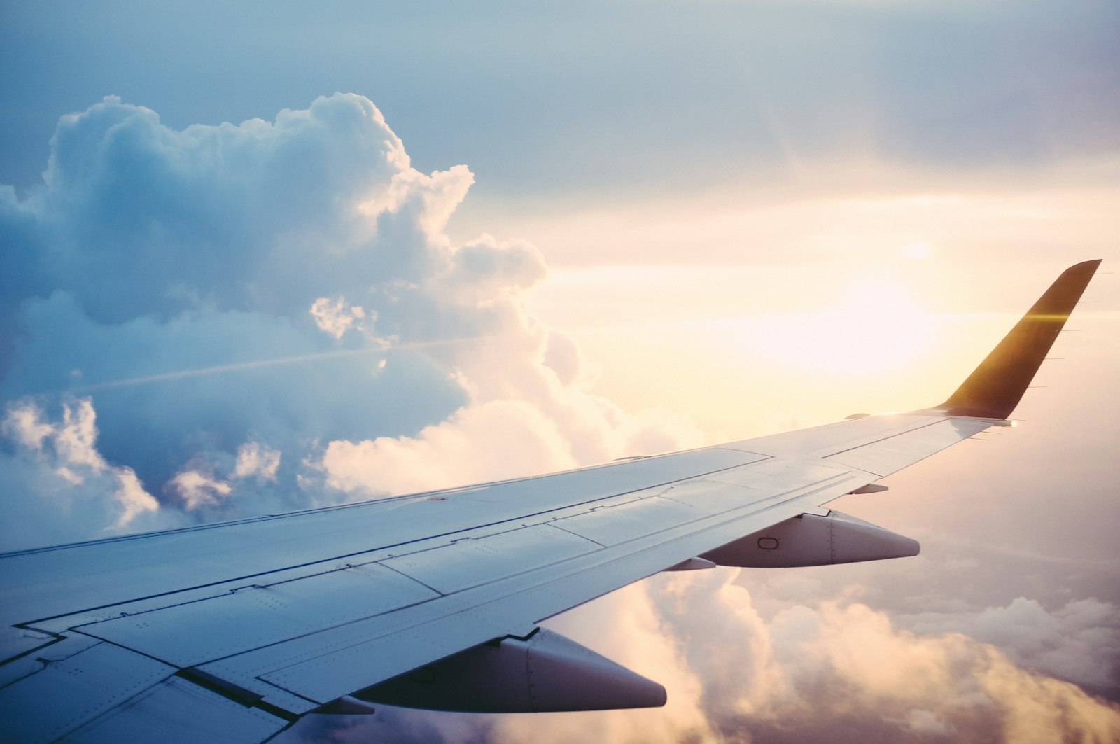 Aircraft wing above the clouds at sunset